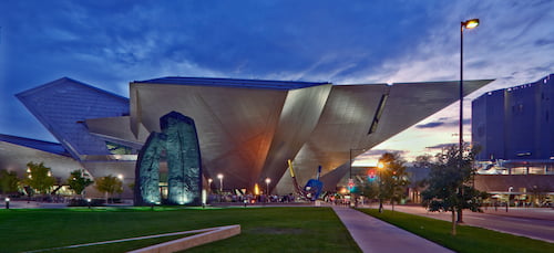 an angular, colorfully lit building shaped like an inverted pyramid