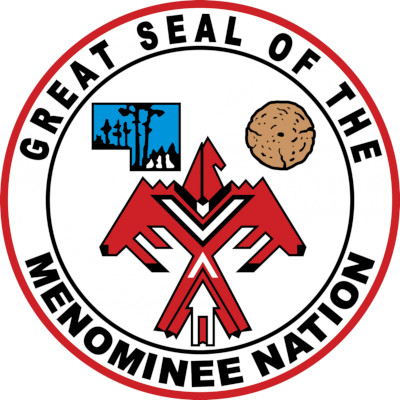 The Great Seal of the Menominee Nation, a stylized red thunderbird with its tail split by an upward-pointing arrow, and a log and a map of the reservation over the bird's shoulders. The map has a small landscape of a forest in it.