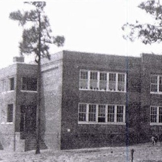 Very old black and white photo of a large brick building.